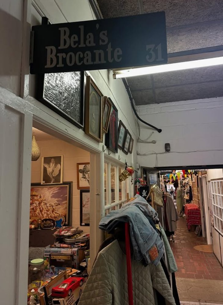 Bela's Brocante at unit 31, pictures and collectables around the doorway, looking on down the market corridor
