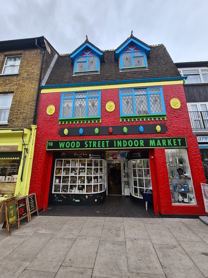 The painted frontage of 98 Wood Street Indoor Market, red with blue and green window frames and the market name above the door