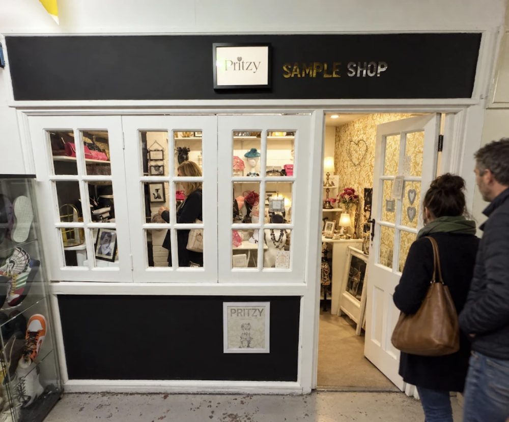 The Pritzy shopfront, a black fascia over white-framed windows of bags, hats and jewellery, with the door open onto the room beyond