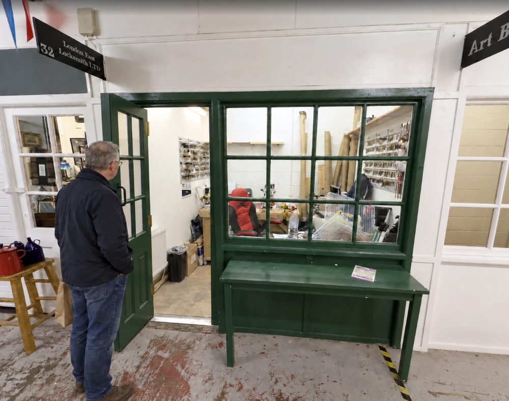 London East Locksmith Ltd at unit 32, a green shopfront with the door open onto a workshop lined with key blanks